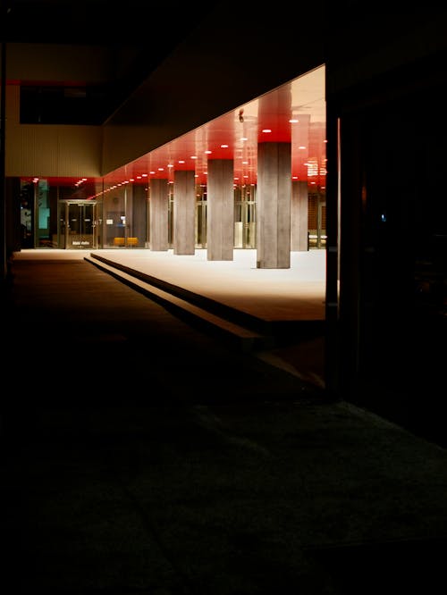 A dark hallway with red lights and columns