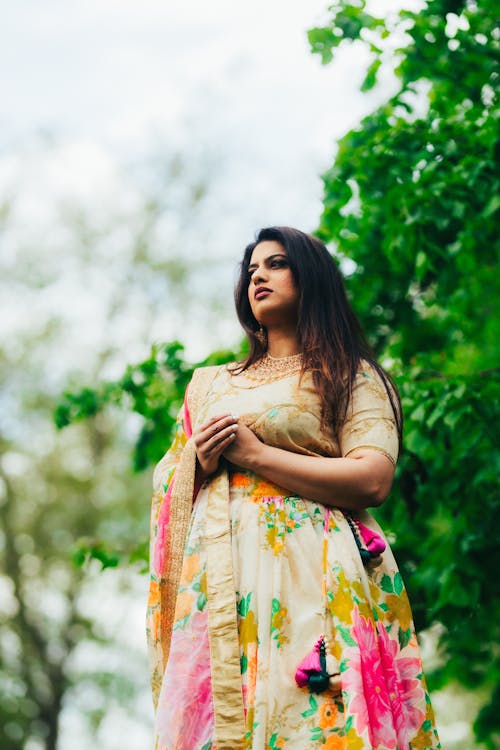 A woman in a floral lehenga with a pink and yellow sari
