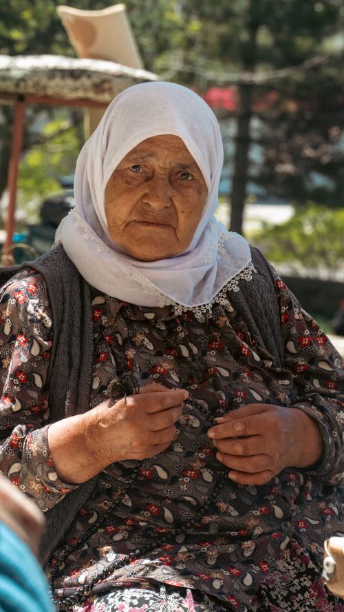 Free Portrait of an elderly woman wearing traditional Turkish clothing and hijab, outdoors in Niğde, Türkiye. Stock Photo