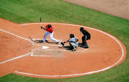 Baseball Player Standing on Baseball Stadium With Two Men