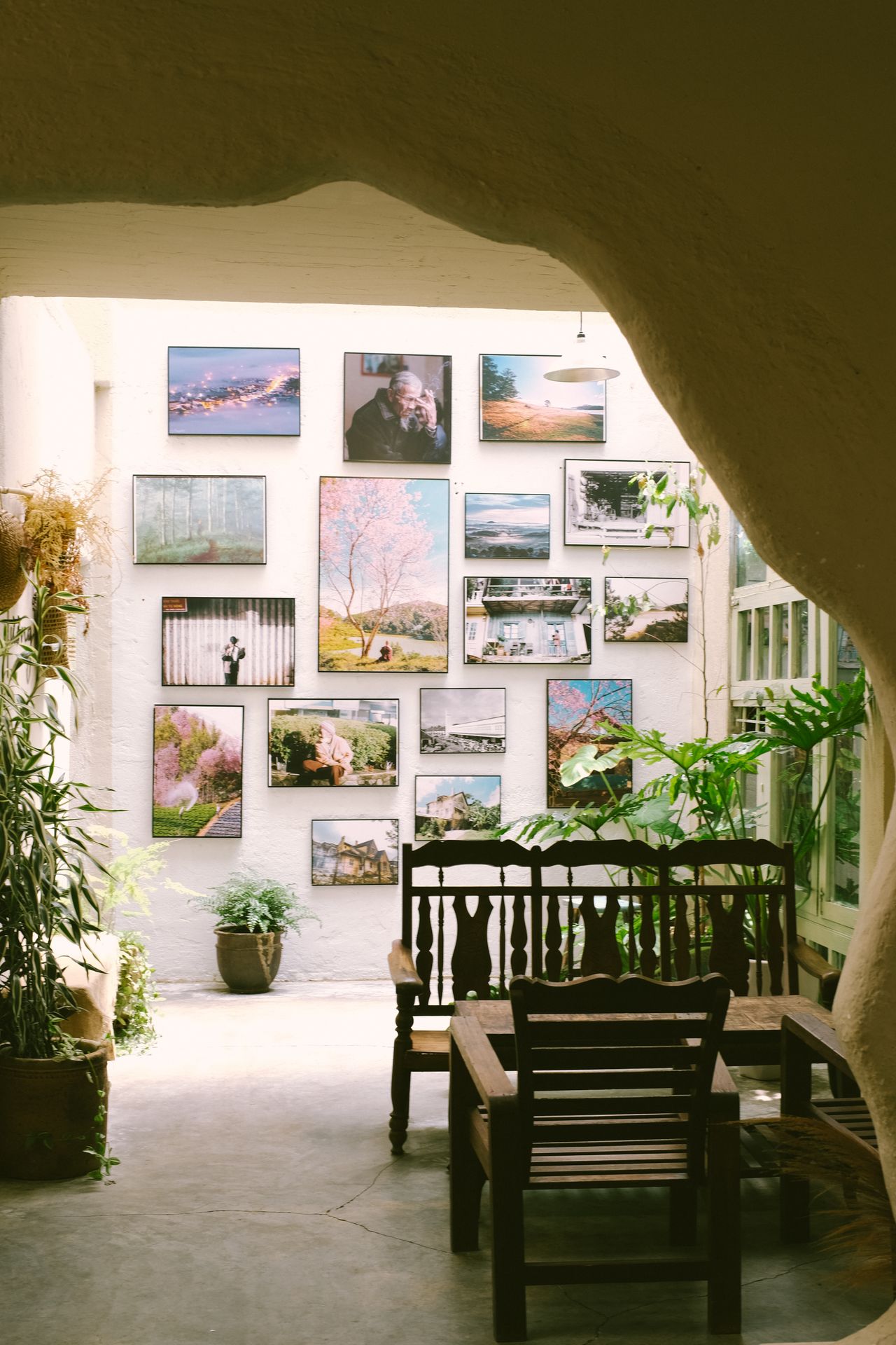 Framed art arranged on a white wall above a wooden table