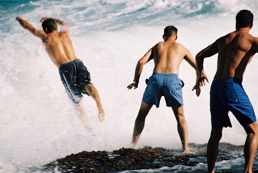 Three men surfing waves in Australia, showcasing active lifestyle at the beach.