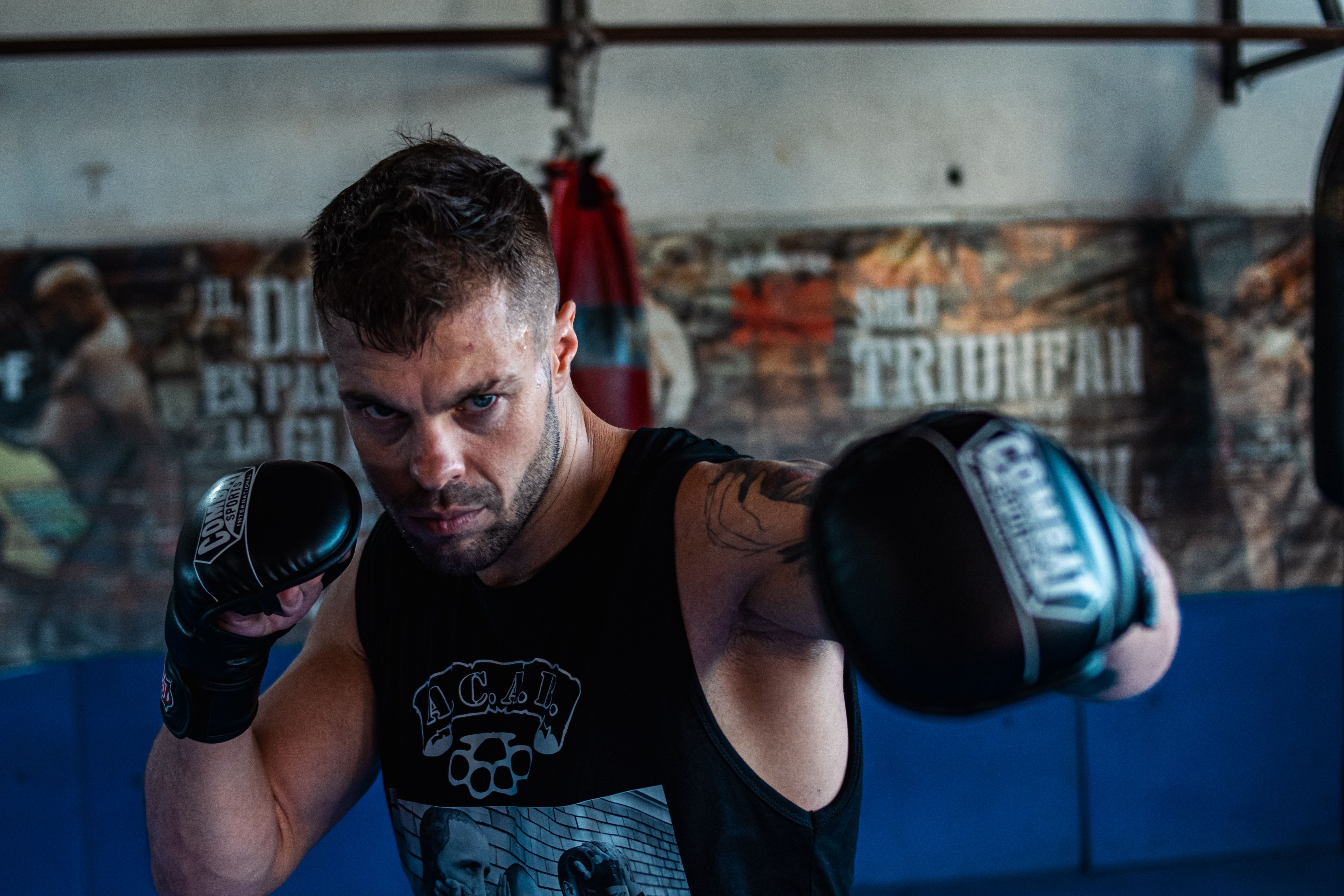 Strong male boxer honing his skills in a gym, showcasing intense focus and athletic agility.