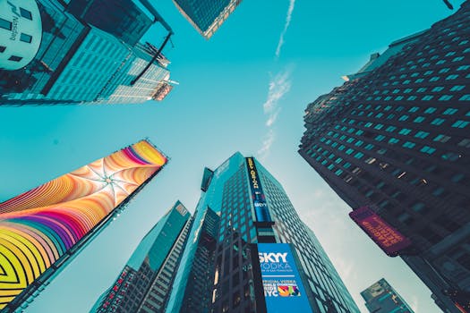 A low angle view of colorful skyscrapers in New York City with vivid signage.
