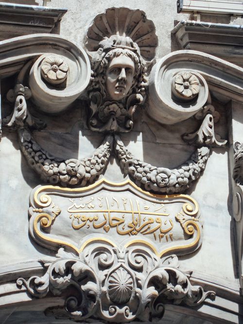 Free Close-up of intricate stone carvings featuring a face and floral motifs in bright sunlight. Stock Photo