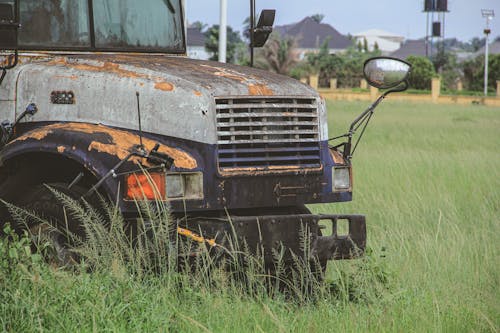 A rusted out truck sitting in a field