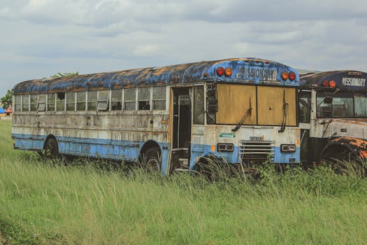 Rustic buses with 'Missionary' signs parked in a grassy field.
