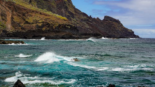 A rocky shore with waves crashing into the shore