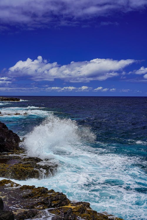 A rocky shoreline with waves crashing into the ocean