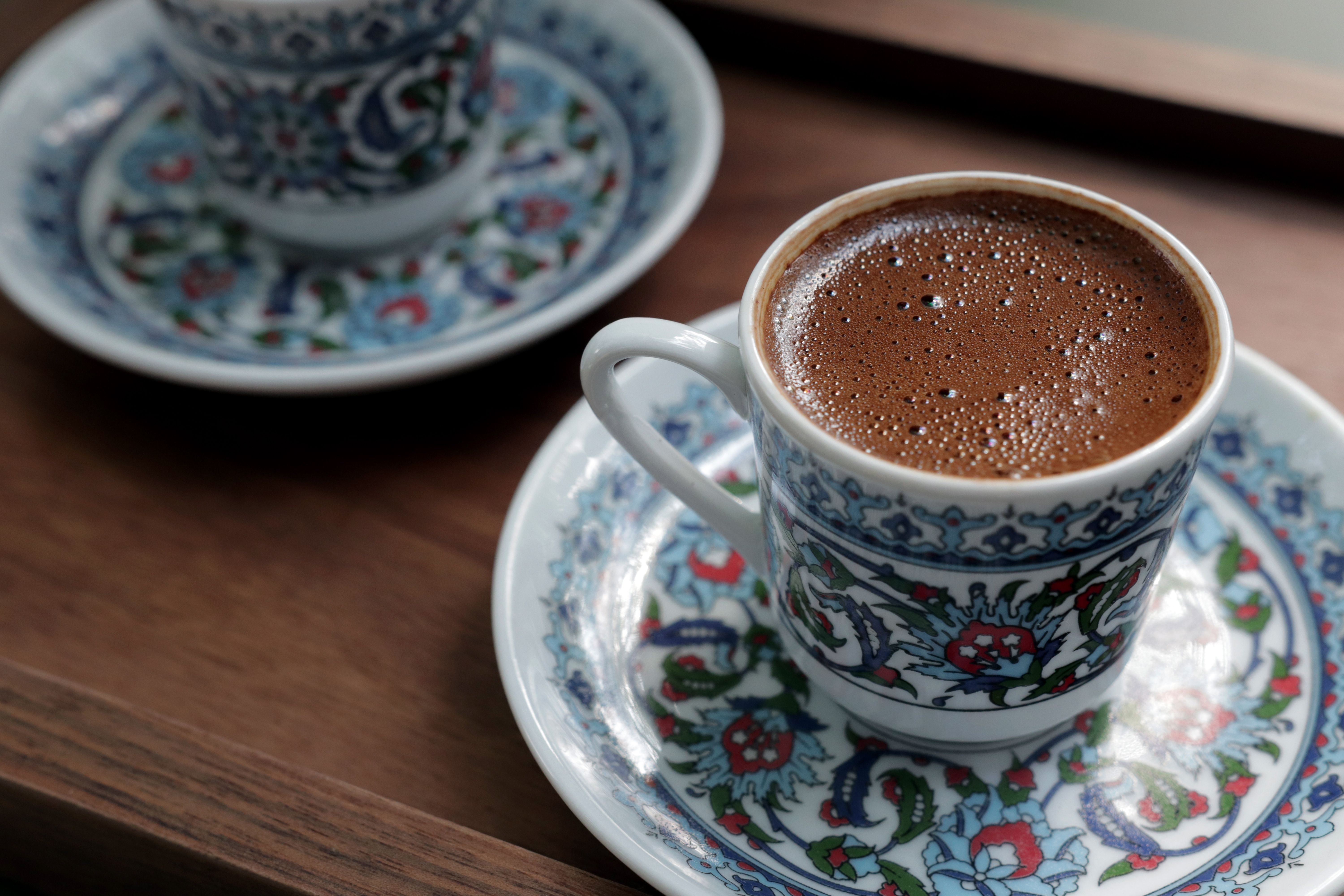 Steaming Turkish coffee served in decorative hand-painted porcelain cups.