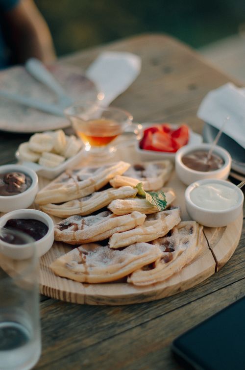 Free A mouth-watering waffle breakfast platter with various sweet toppings on a rustic wooden table. Stock Photo