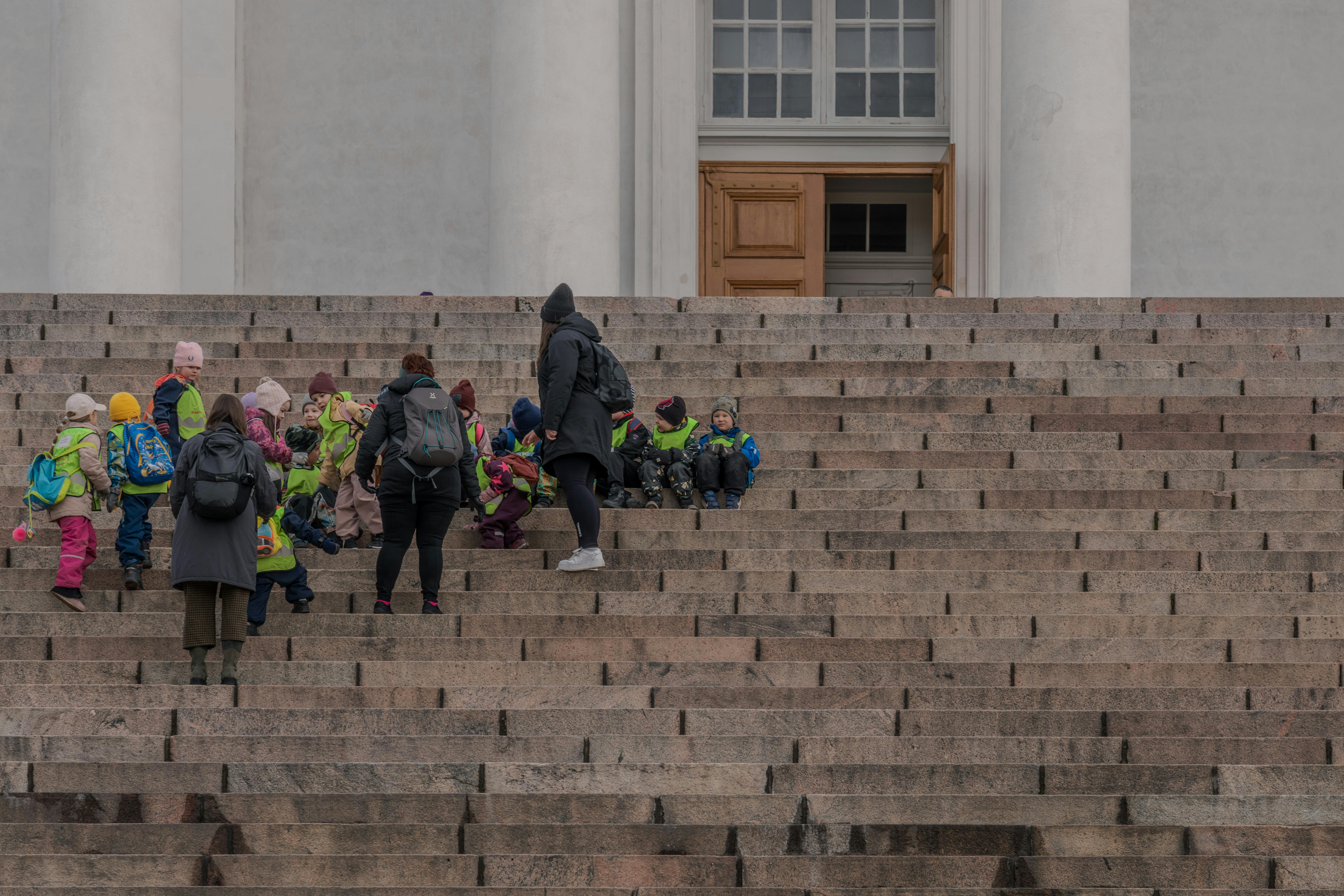 women with group of preschoolers on steps of helsinki cathedral