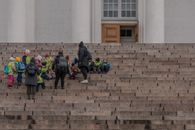 A group of children and adults on the steps of Helsinki Cathedral during a field trip.
