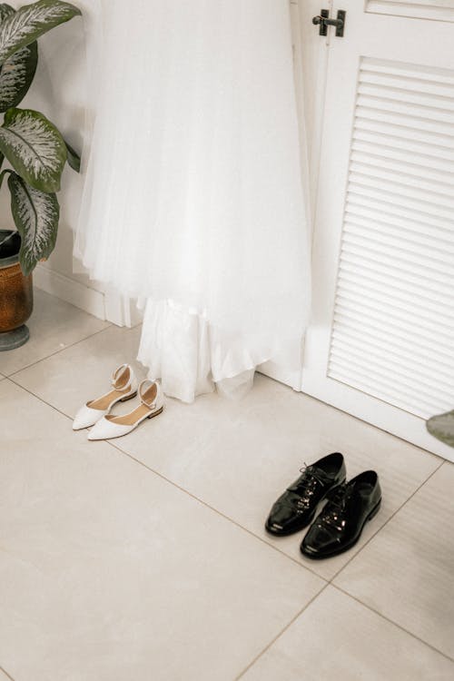 A wedding dress and shoes on a tile floor