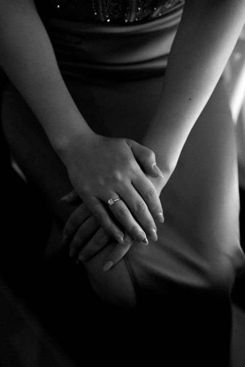 Free A black and white close-up shot of a woman's hands resting on her lap in an elegant dress. Stock Photo