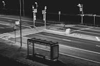 黑白图像中，夜间空荡荡的城市人行横道和公交车站