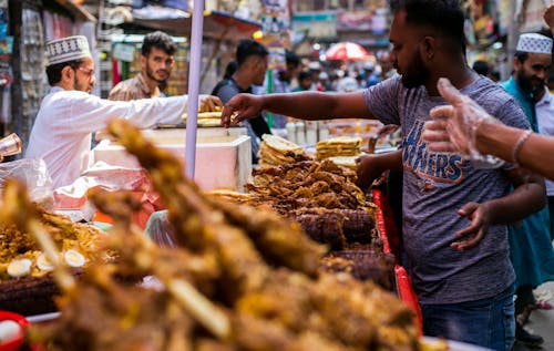 Free A man is buying food at a market Stock Photo