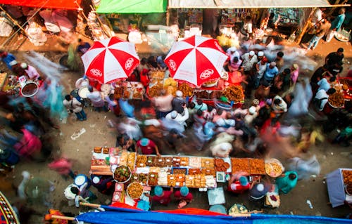 Free A crowd of people at a market with umbrellas Stock Photo