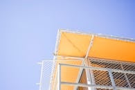 低角度拍摄的黄色金属结构，以蓝天为背景，非常适合现代设计理念