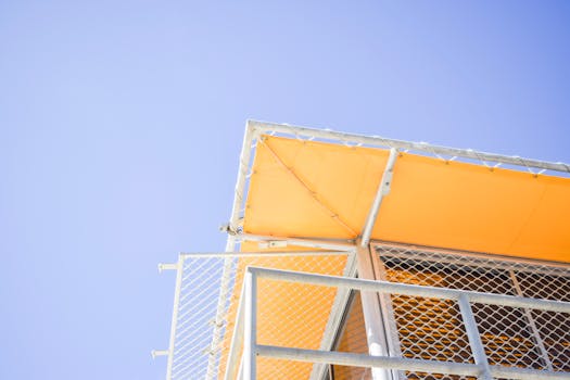 低角度拍摄的黄色金属结构，以蓝天为背景，非常适合现代设计理念