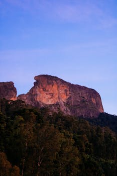 悬崖的壮丽景色，在充满活力的日落天空下，被大自然环绕