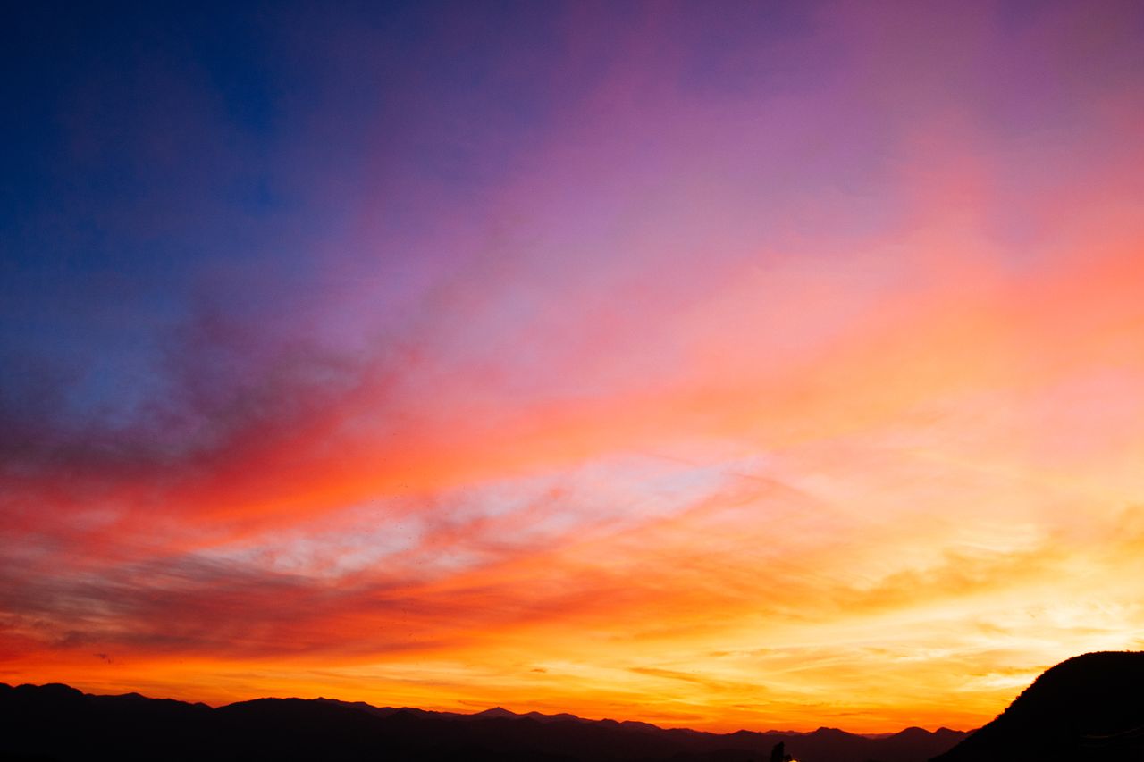 beautiful colorful sunset sky with vibrant hues over mountain silhouet