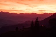 日落令人惊叹，山脉的轮廓与天空的鲜艳色彩，共同营造出宁静的景观