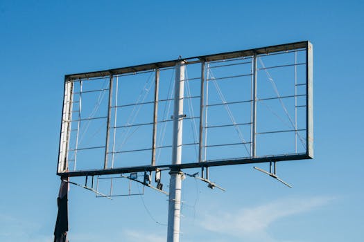 晴朗的蓝天下，空荡荡的金属广告牌框架矗立着，凸显了户外广告的基础设施