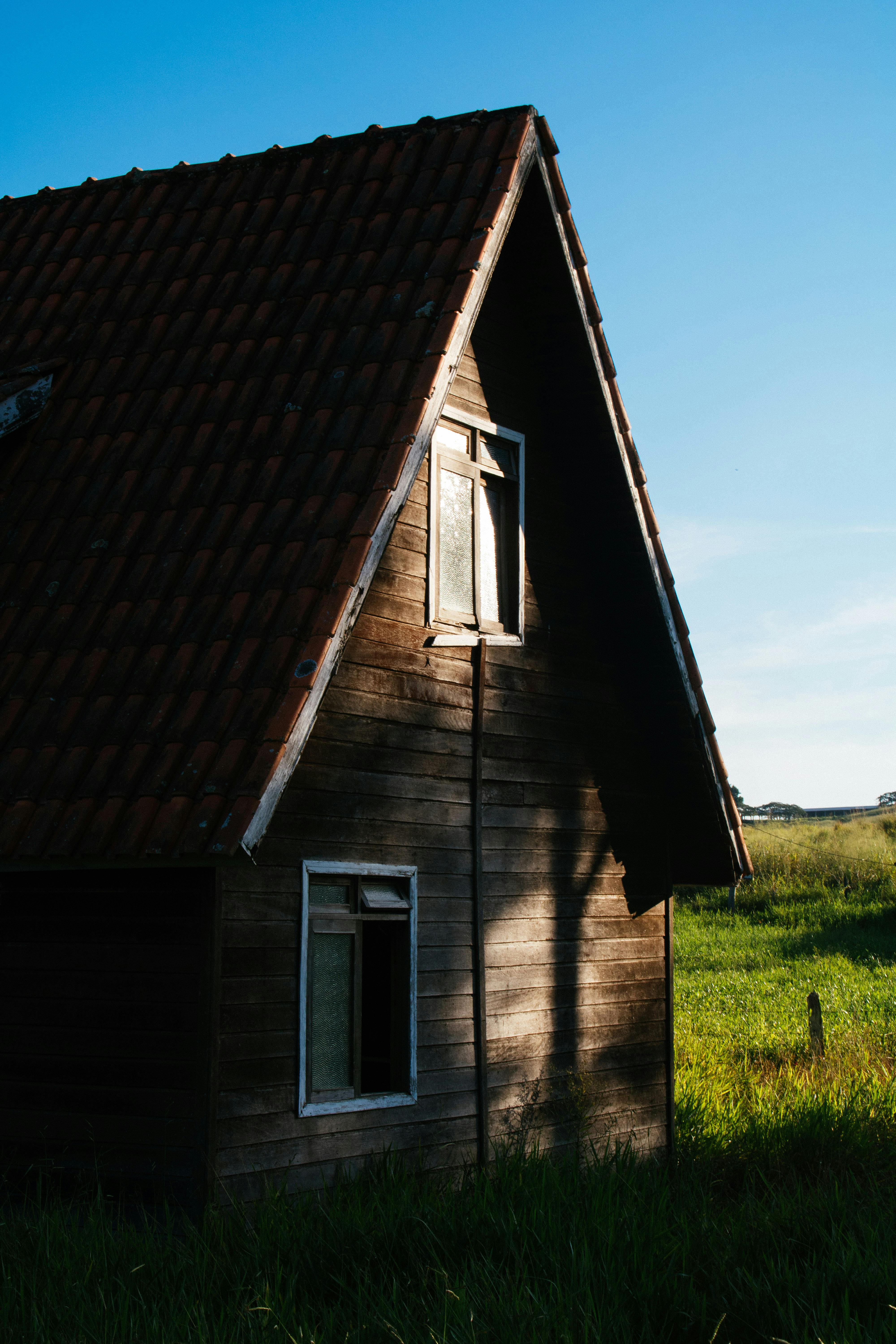 一座有瓷砖屋顶的质朴木屋，被落日余晖照亮