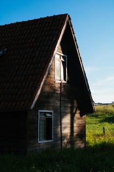 一座有瓷砖屋顶的质朴木屋，被落日余晖照亮