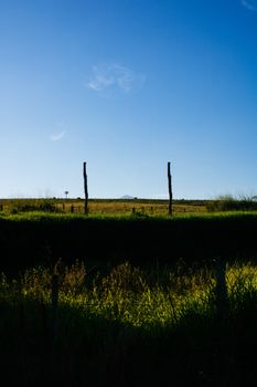 Peaceful rural countryside scene with open fields under a clear blue sky. Perfect for nature themes.