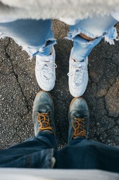 A close-up of casual sneakers and rugged boots, showcasing urban fashion style.
