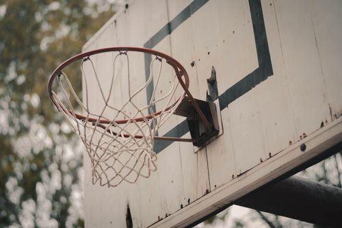 Free A weathered basketball hoop on a rustic outdoor court capturing a vintage feel. Stock Photo