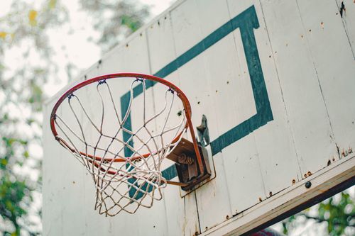 Free Close-up image of an outdoor basketball hoop and weathered white backboard, ideal for sports themes. Stock Photo