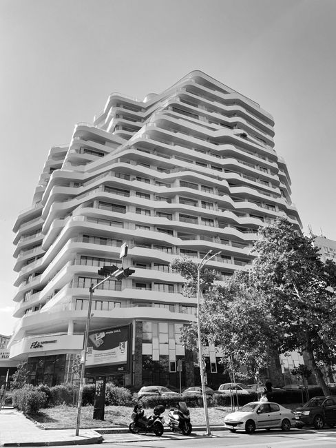 Monochrome shot of a uniquely designed apartment building in an urban city setting.