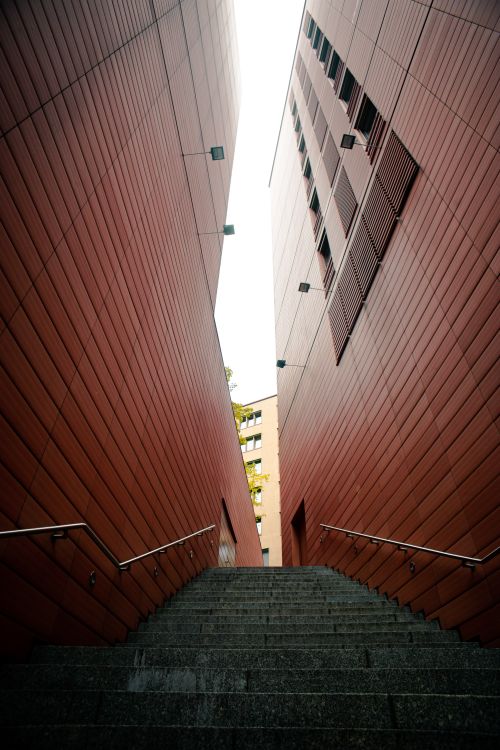 Free Dramatic stairway view between two modern red buildings with geometric patterns. Stock Photo