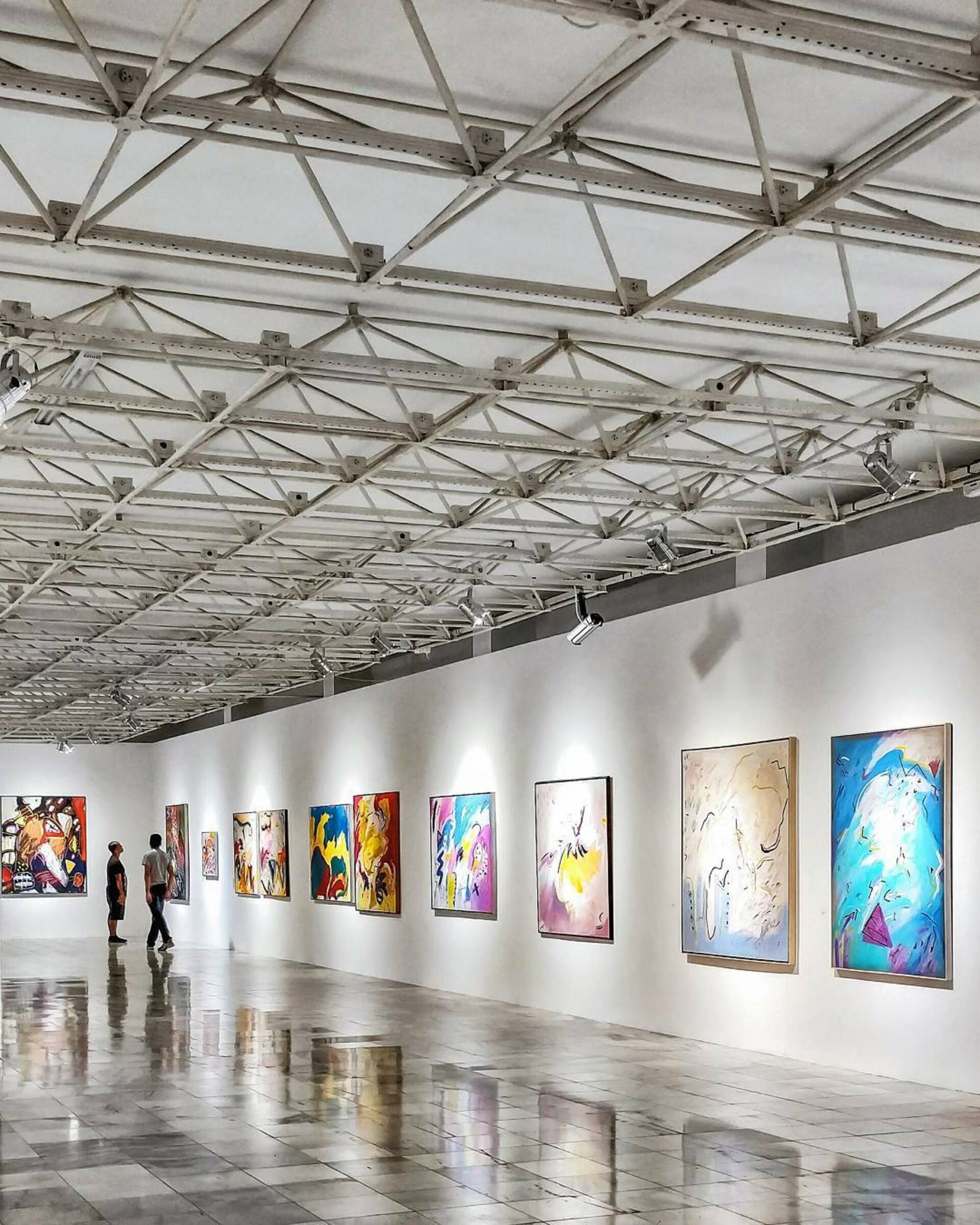 A bright gallery room hung with framed works
