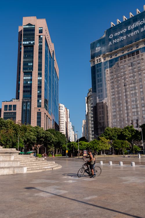 Free A cyclist rides through Maua Square in Rio de Janeiro, surrounded by modern skyscrapers. Stock Photo