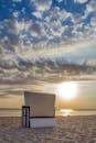 日出时分，海滩宁静，一把空椅子面朝大海，云层壮观
