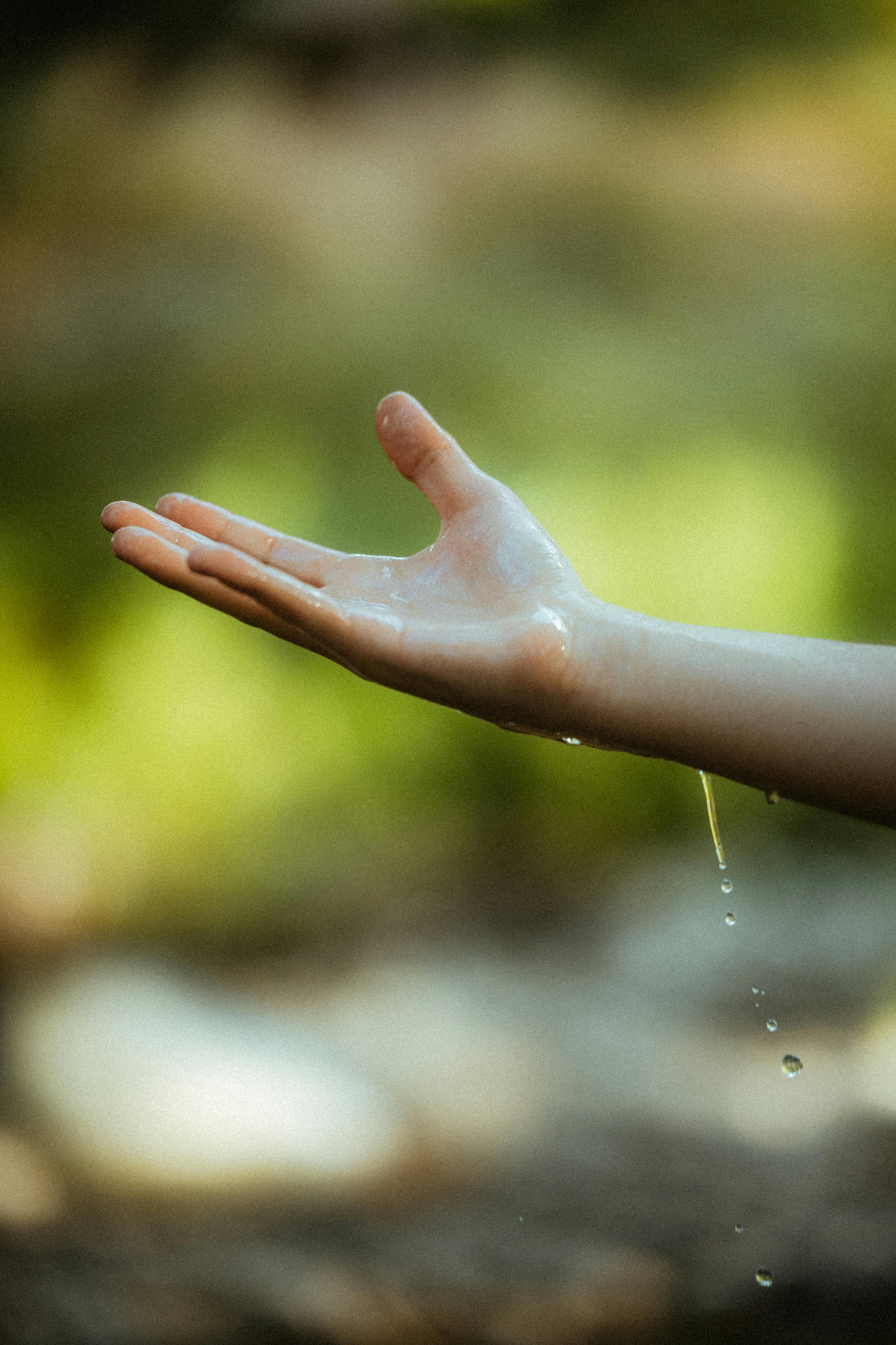 A Hand Feeling the Raindrops · Free Stock Photo