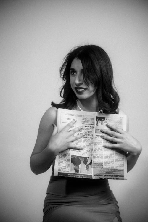 Free Stylish woman holding a newspaper in a vintage black and white portrait, exuding elegance and charm. Stock Photo