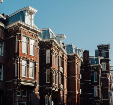 Charming historic buildings showcasing Amsterdam's classic urban architecture under clear skies.