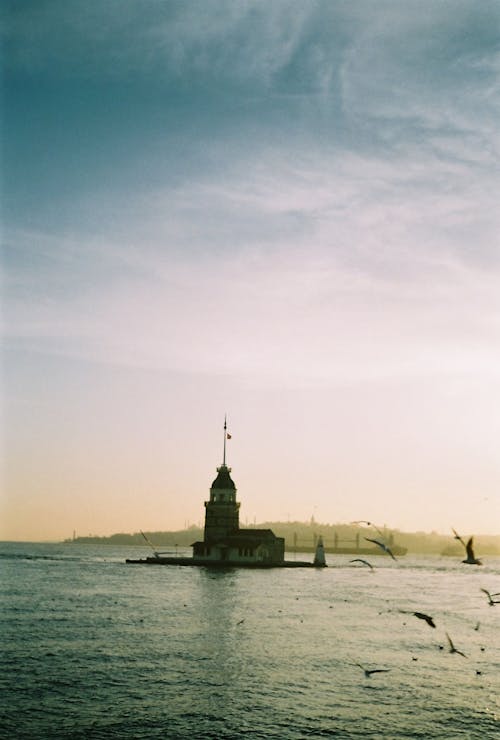 A lighthouse is on the water near a body of water