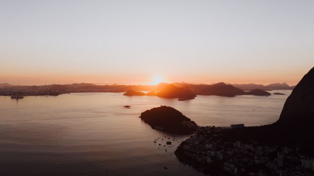 Breathtaking aerial shot of Rio de Janeiro's coast at sunset, showcasing mountains and ocean.