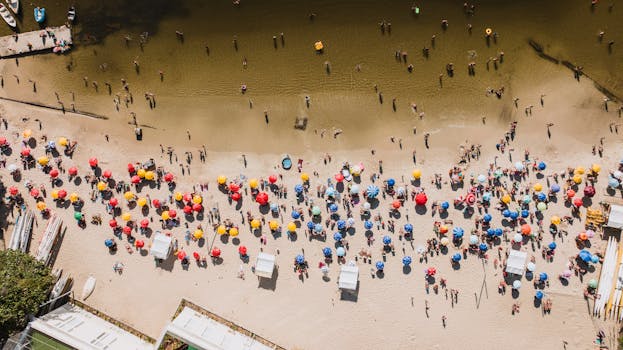 A vibrant aerial shot of Rio de Janeiro beach with colorful umbrellas and sunbathers enjoying a sunny day.