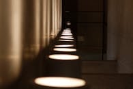 黑暗、现代的走廊中，戏剧性的灯光与地板上的倒影交相辉映