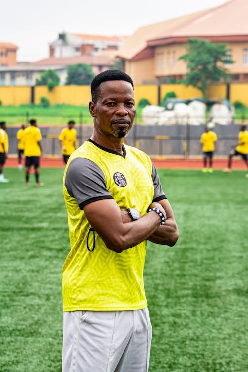 A man in yellow and black standing on a soccer field
