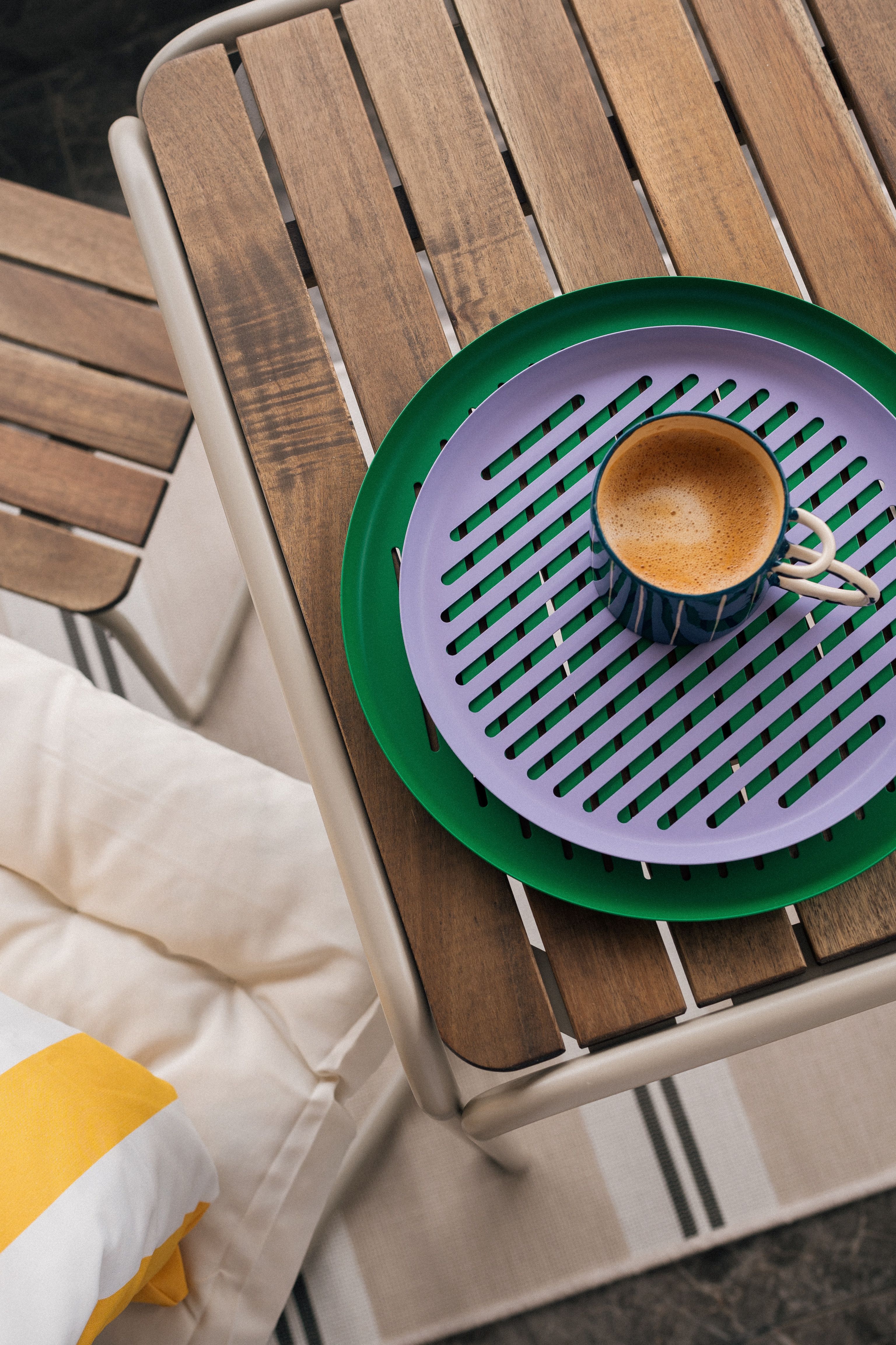 A coffee cup on a colourful tray, with small domestic colour doing more work than a full renovation