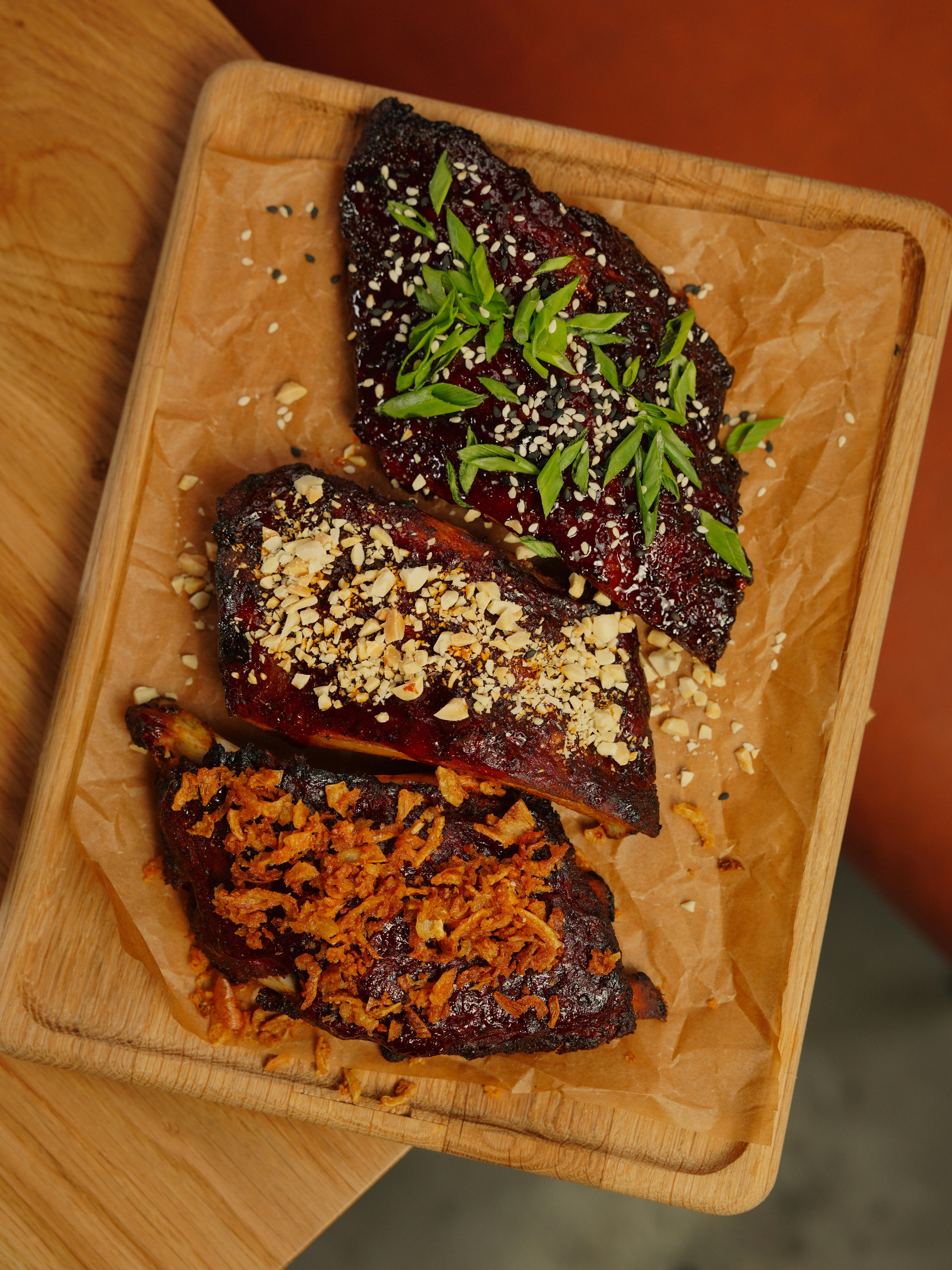 Close-up of grilled Tony Roma's style ribs served on a wooden board with garnish