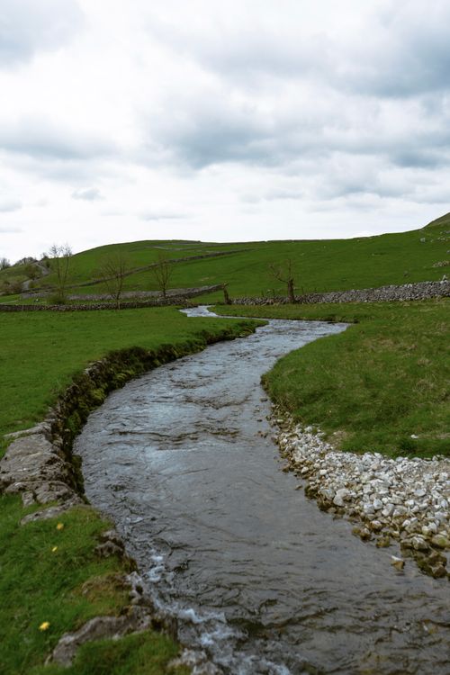 View of a River Flowing between Green Hills · Free Stock Photo
